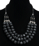 Collier ethnique artisanal trois rangs imitation pierres noires agrementees de perles et d'armatures argentees ciselees