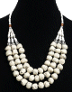 Collier ethnique artisanal trois rangs imitation pierres blanches agrementees de perles et de pieces argentees ciselees
